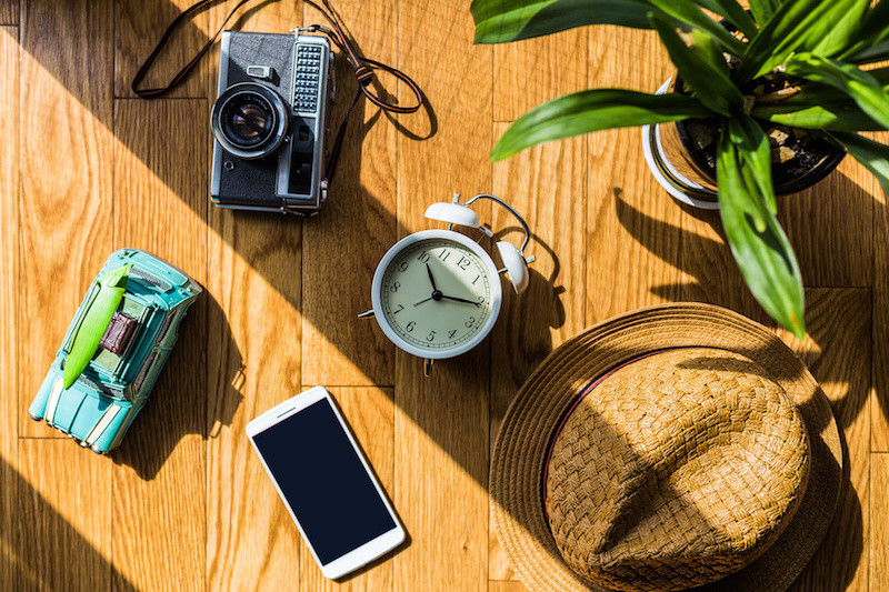 床に置かれた時計や、帽子、スマートフォン、カメラ